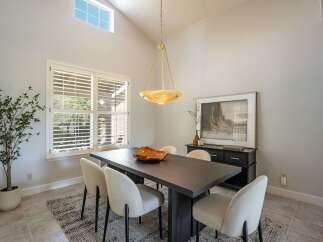 This dining room features a large, dark wood dining table with six upholstered chairs, perfect for family gatherings.