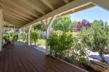 Enjoy the outdoors from this charming covered porch, perfect for relaxing with a cup of coffee.