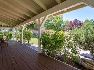 Enjoy the outdoors from this charming covered porch, perfect for relaxing with a cup of coffee.