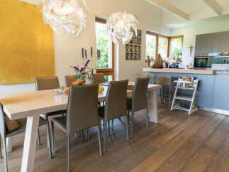 This stunning dining area features a modern design with a sleek wooden table and comfortable chairs.
