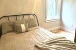 Discover comfort and style in this inviting bedroom, featuring a cozy bed adorned with plush pillows and a soft, quilted comforter.