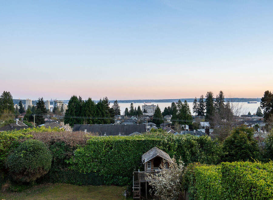 Enjoy stunning views from this beautiful property, featuring a charming playhouse and lush greenery.