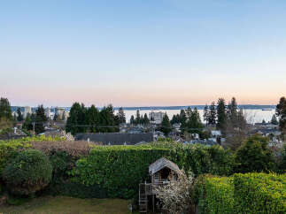 Enjoy stunning views from this beautiful property, featuring a charming playhouse and lush greenery.