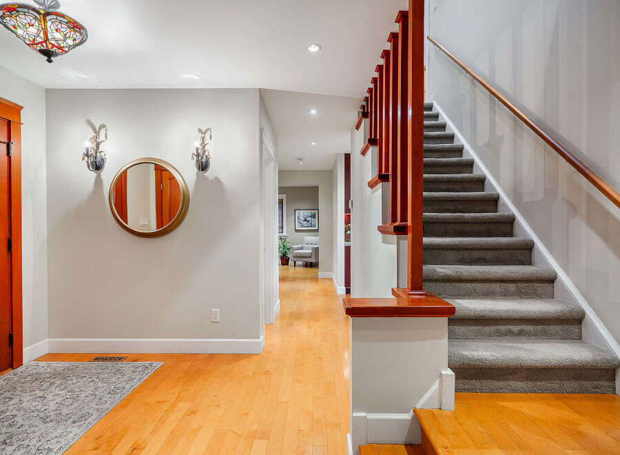 Step into this inviting entryway, showcasing a beautiful staircase and warm hardwood floors.