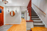 Step into this inviting entryway, showcasing a beautiful staircase and warm hardwood floors.