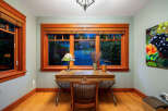 Step into this inviting home office, featuring stunning natural light and elegant wood accents.