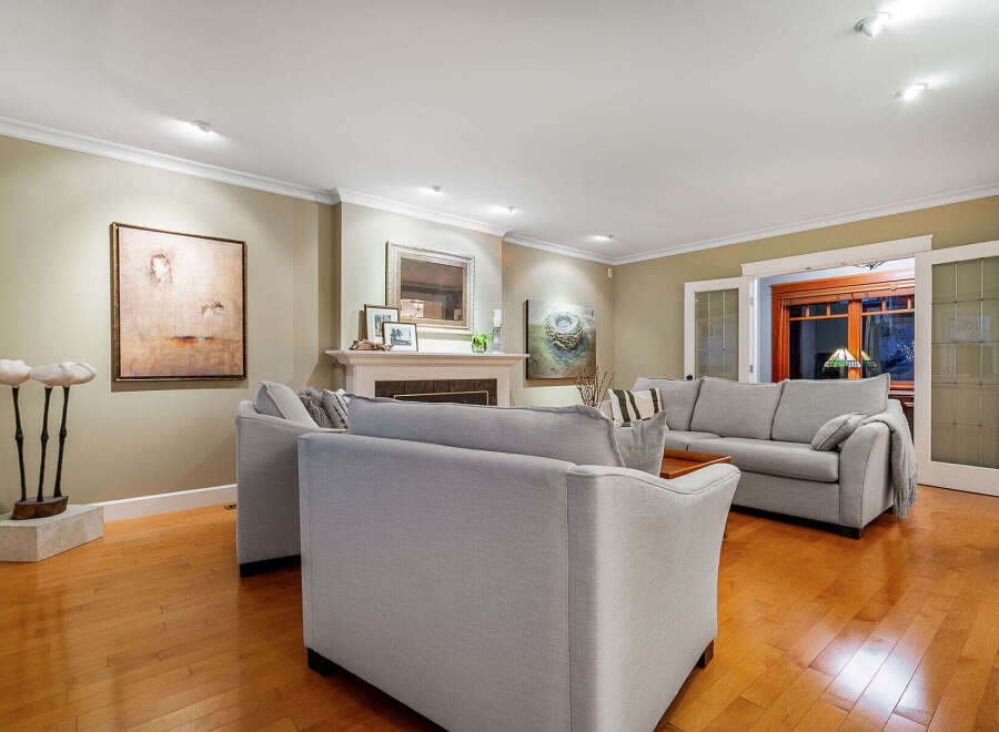 Step into luxury with this stunning living room, featuring a cozy fireplace and elegant hardwood floors.