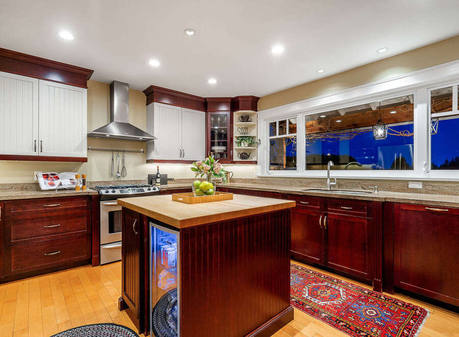This stunning kitchen boasts a modern design with rich, dark wood cabinetry and a contrasting light countertop.