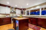 This stunning kitchen boasts a modern design with rich, dark wood cabinetry and a contrasting light countertop.