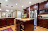 This stunning kitchen boasts rich, dark wood cabinetry and a spacious island with a butcher block countertop, perfect for meal preparation and entertaining.