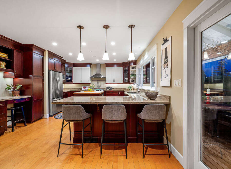 This stunning kitchen boasts rich, dark wood cabinetry and a spacious layout, perfect for both cooking and entertaining.