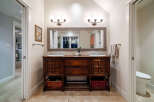 This stunning bathroom features a beautiful wooden vanity with dual sinks, offering ample storage and a touch of classic elegance.