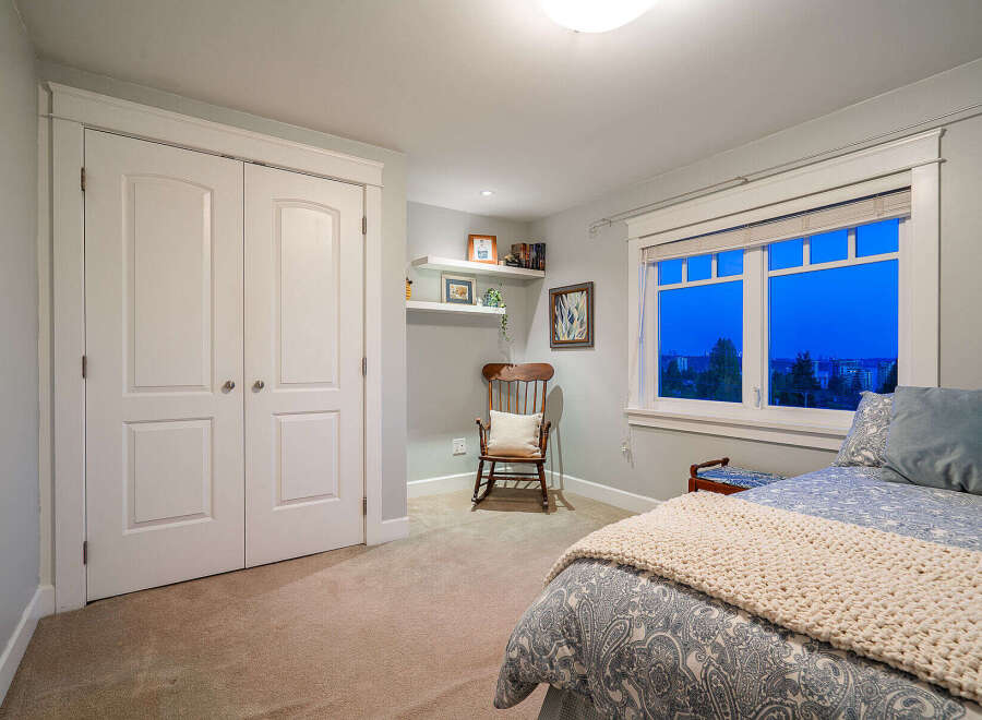 Step into this inviting bedroom, featuring a cozy rocking chair and a serene ambiance.