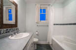 Step into this beautifully designed bathroom, featuring a sleek vanity and a pristine sink.