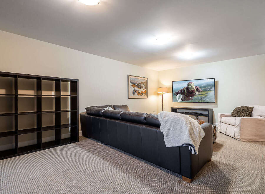This inviting living space features a sleek black leather sofa, perfect for relaxing and entertaining.