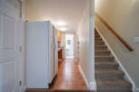 Step into this inviting space featuring a well-lit hallway with a kitchen and staircase.