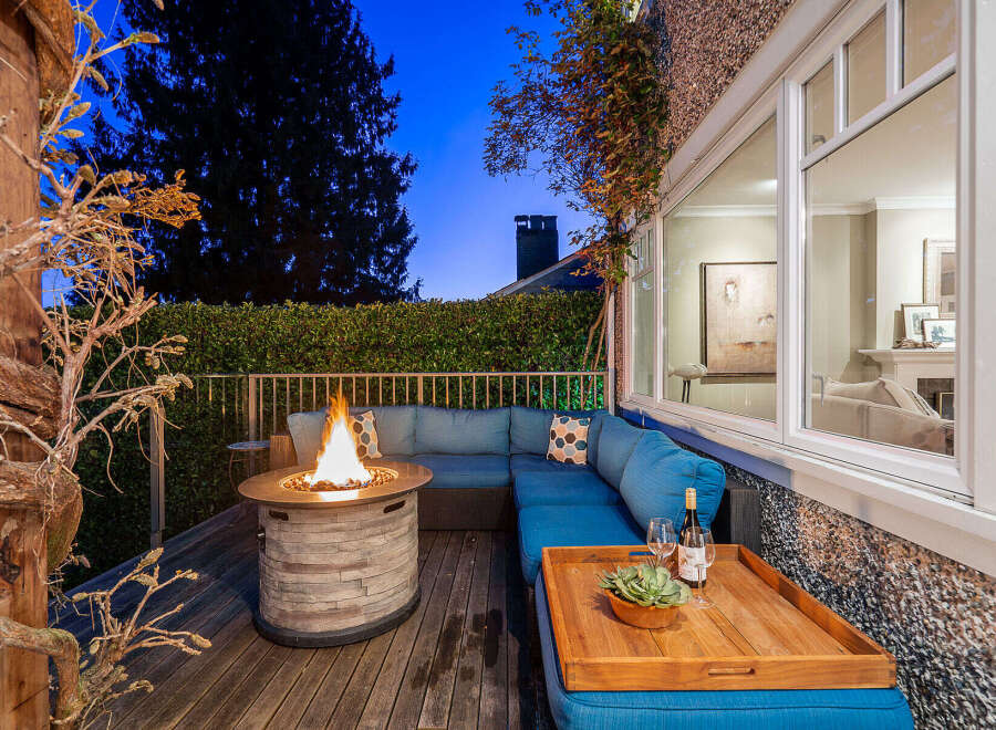 Experience luxury living in this stunning property featuring a cozy outdoor seating area with a fire pit, perfect for evening gatherings.