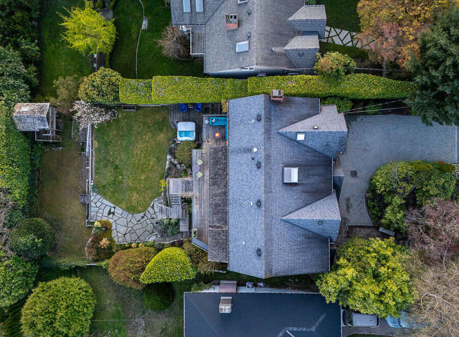 This stunning property boasts a beautifully landscaped backyard with a lush green lawn and a relaxing hot tub.