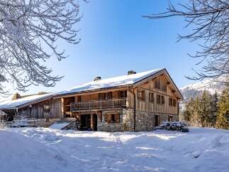 Discover the charm of this stunning wooden chalet nestled in a snowy landscape.