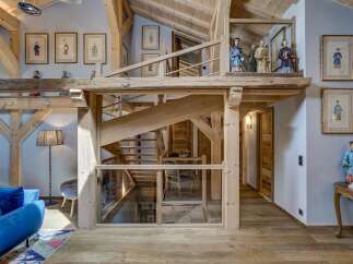 Step into luxury with this stunning property featuring a unique wooden staircase and exposed beams, creating a warm and inviting atmosphere.
