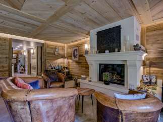 Step into luxury with this stunning living space, featuring a cozy fireplace and exquisite wooden accents.