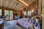 Experience rustic elegance in this stunning bedroom featuring exposed wooden beams and walls, creating a warm and inviting atmosphere.