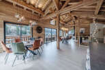 Experience luxury living in this stunning chalet, featuring a spacious dining area with a rustic wooden design.