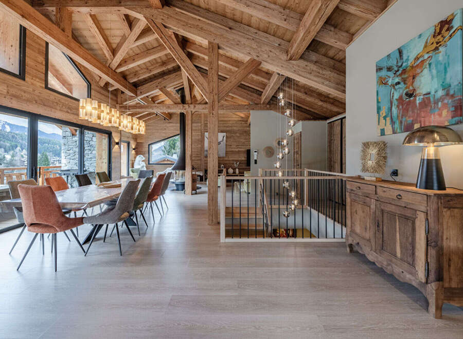 Experience luxury living in this stunning chalet, featuring a spacious dining area with a large table and stylish chairs, perfect for entertaining.