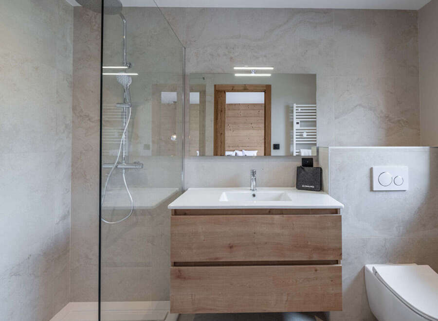 Step into a modern bathroom oasis, featuring a sleek glass shower enclosure and elegant vanity.