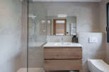 Step into a modern bathroom oasis, featuring a sleek glass shower enclosure and elegant vanity.