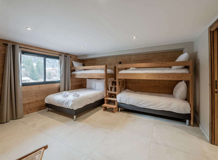 This cozy bedroom features two sets of bunk beds, perfect for accommodating a large family or group of friends.