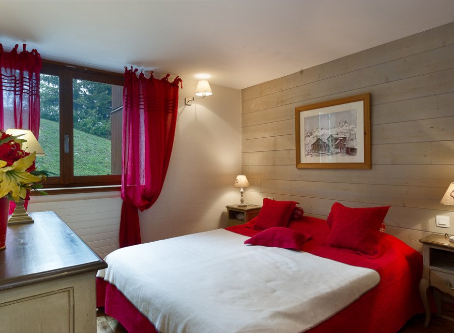 Cozy bedroom with a mountain view and red accents.