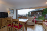 This stunning chalet boasts breathtaking mountain views from its large windows, creating a bright and airy living space.