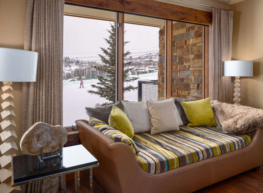 This luxurious living space offers stunning views of a snowy ski resort, perfect for those seeking a mountain retreat.