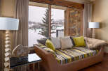 This luxurious living space offers stunning views of a snowy ski resort, perfect for those seeking a mountain retreat.