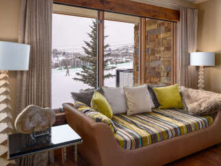 This luxurious living space offers stunning views of a snowy ski resort, perfect for those seeking a mountain retreat.