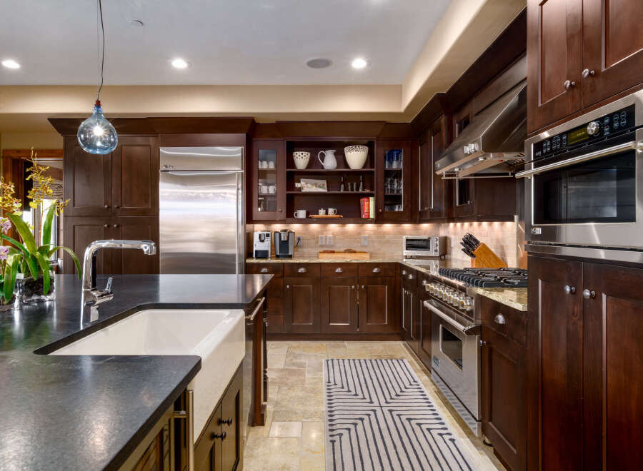 This stunning kitchen boasts rich, dark wood cabinetry and stainless steel appliances, creating a warm and inviting atmosphere.