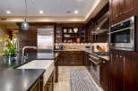 This stunning kitchen boasts rich, dark wood cabinetry and stainless steel appliances, creating a warm and inviting atmosphere.