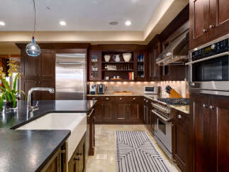 This stunning kitchen boasts rich, dark wood cabinetry and stainless steel appliances, creating a warm and inviting atmosphere.