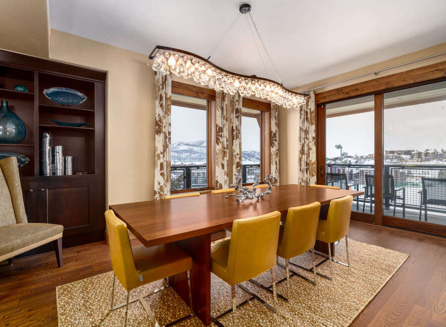 This stunning dining room features a modern design with a beautiful wooden table and stylish yellow chairs.