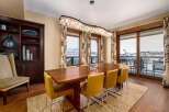 This stunning dining room features a modern design with a beautiful wooden table and stylish yellow chairs.