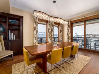 This stunning dining room features a modern design with a beautiful wooden table and stylish yellow chairs.