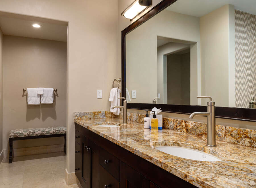 This luxurious bathroom boasts a stunning granite countertop and dark wood cabinetry, creating a sophisticated and inviting space.
