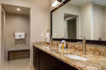 This luxurious bathroom boasts a stunning granite countertop and dark wood cabinetry, creating a sophisticated and inviting space.