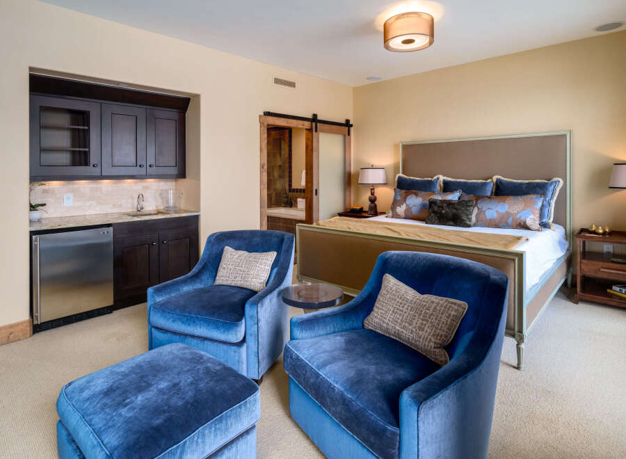 Step into luxury with this stunning bedroom, featuring a private wet bar and elegant seating area.