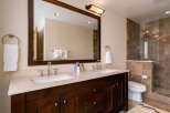 This luxurious bathroom boasts a stunning dark wood vanity with dual sinks, offering ample space and storage.