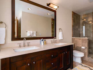 This luxurious bathroom boasts a stunning dark wood vanity with dual sinks, offering ample space and storage.
