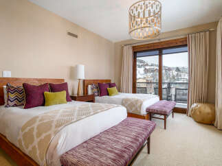Experience luxury in this stunning bedroom featuring two comfortable beds with plush bedding and stylish accent pillows.