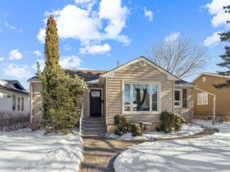 Charming home with a welcoming facade, featuring a well-maintained exterior and a pathway leading to the front door.