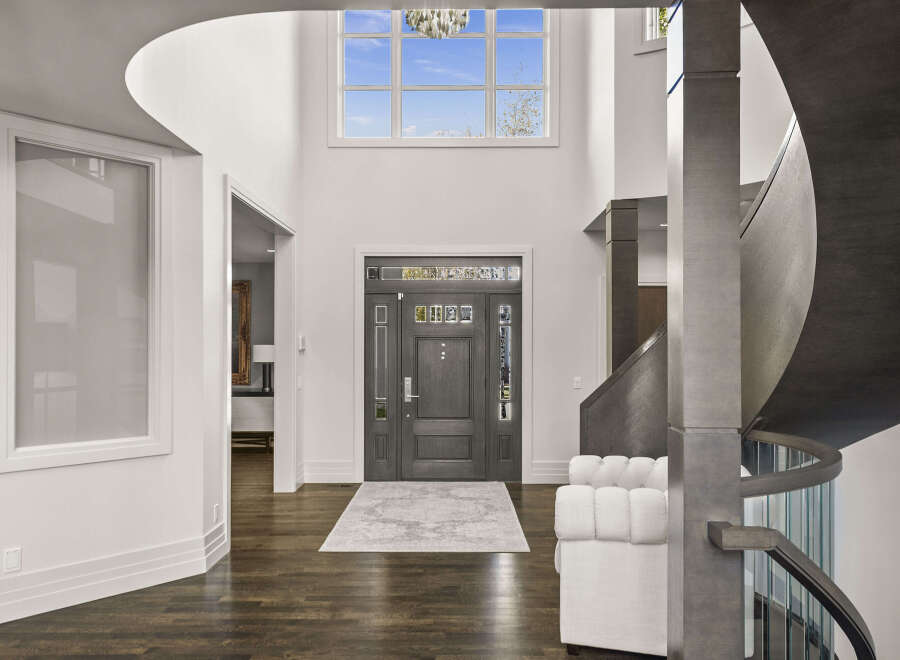 Step into luxury with this stunning entryway, showcasing a grand staircase and soaring ceilings.